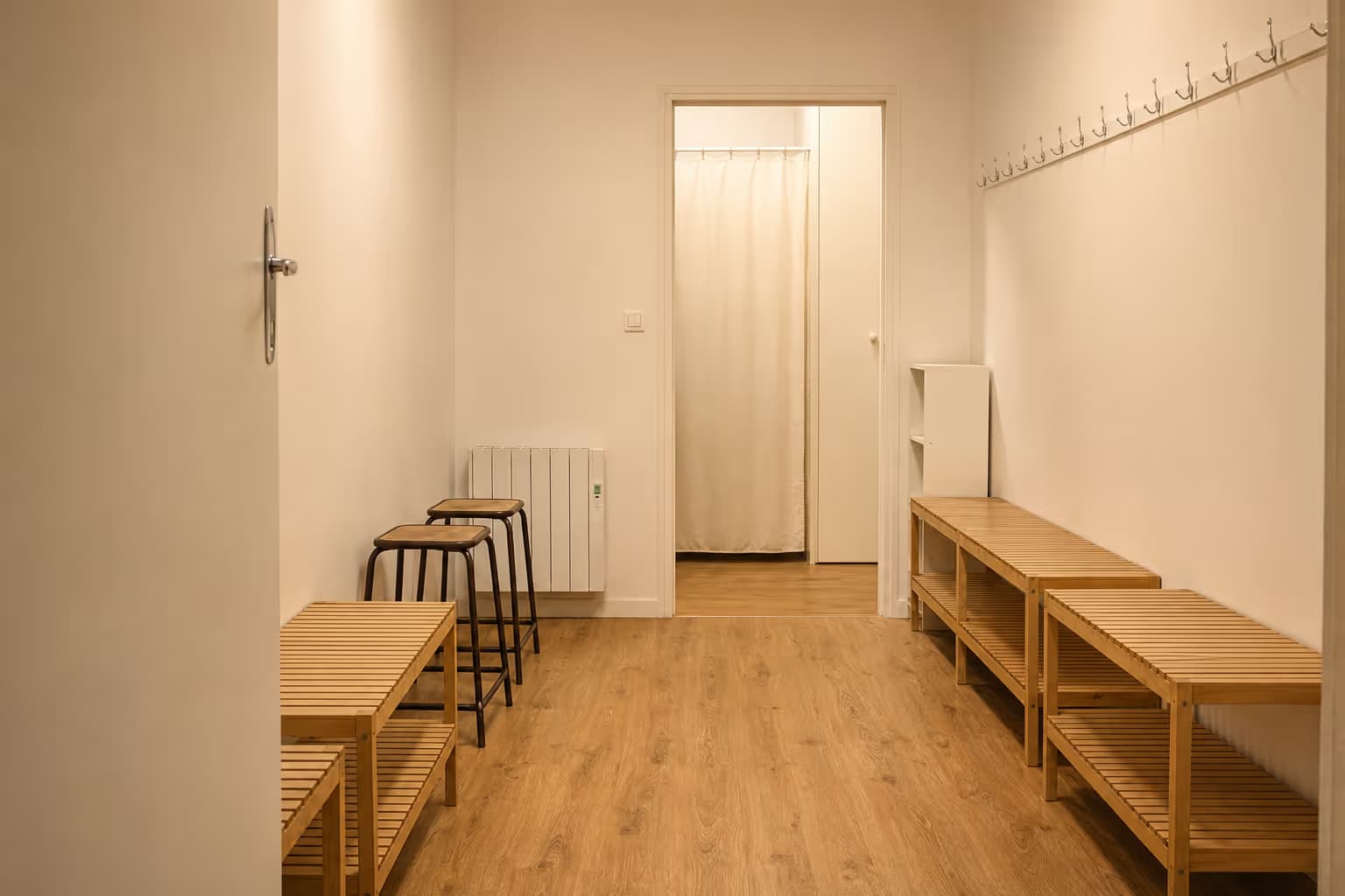 L'entrée et le vestiaire de L'Annexe — bancs en bois, patères et tabourets
